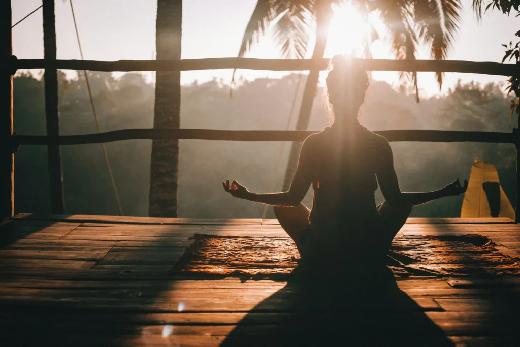 Uma mulher praticando meditação em meio a natureza