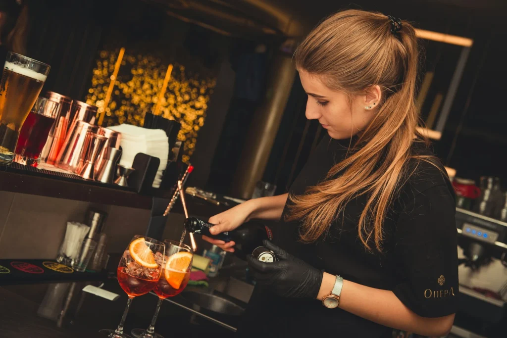 Uma bartender preparando um coquetel