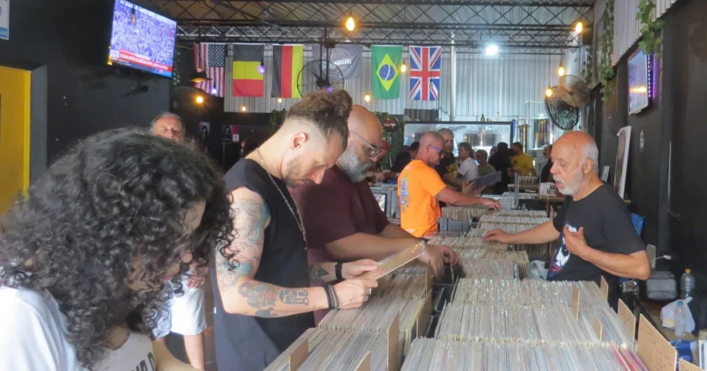 Pessoas buscando por discos de vinil em uma feira
