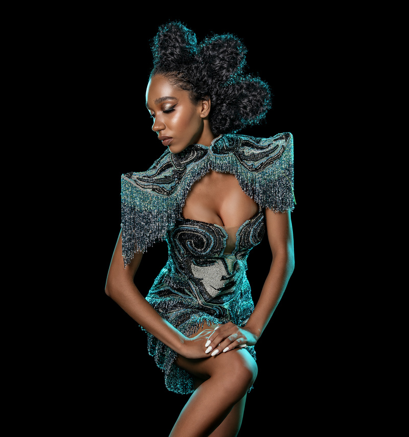 Foto de uma mulher negra com roupa carnavalesca, de alta costura, feita por Henrique Filho