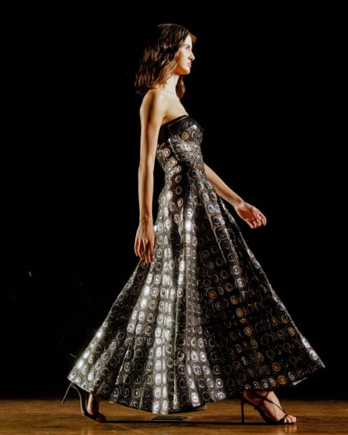 Foto de uma mulher branca desfilando com um vestido