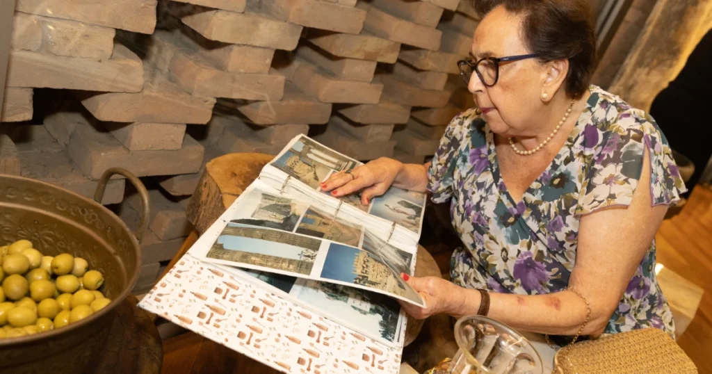 Uma mulher branca, folheando um álbum de fotografias