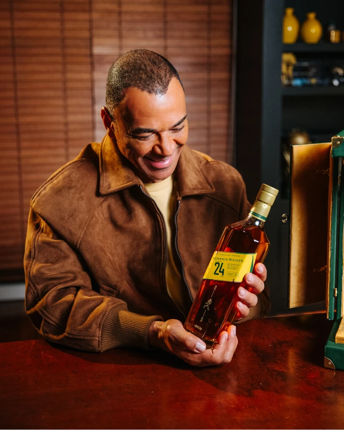 Foto do Cafu olhando para uma garrafa de Johnnie Walker 24 anos