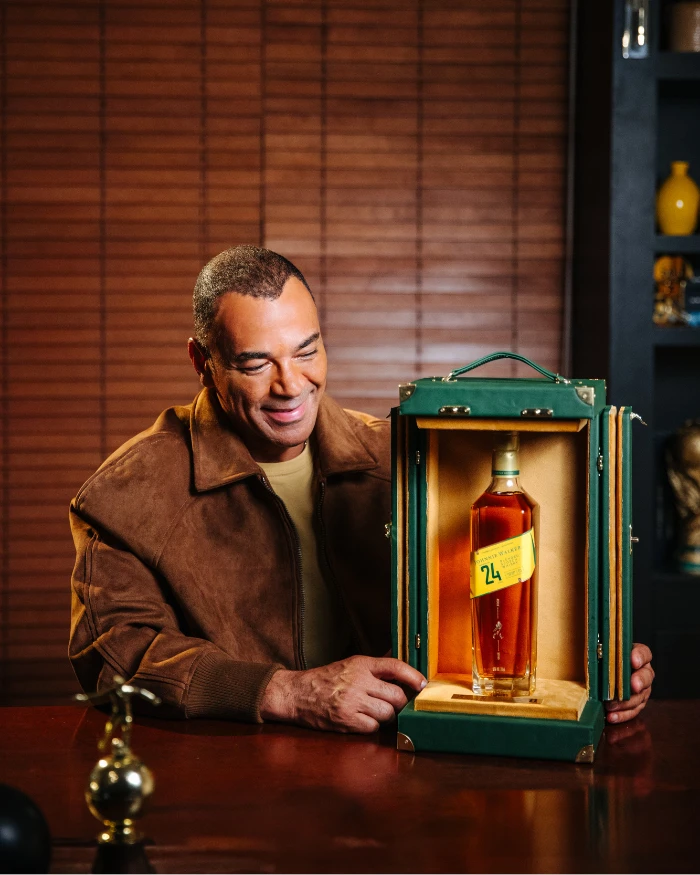 Foto do Cafu olhando para uma garrafa de Johnnie Walker 24 anos