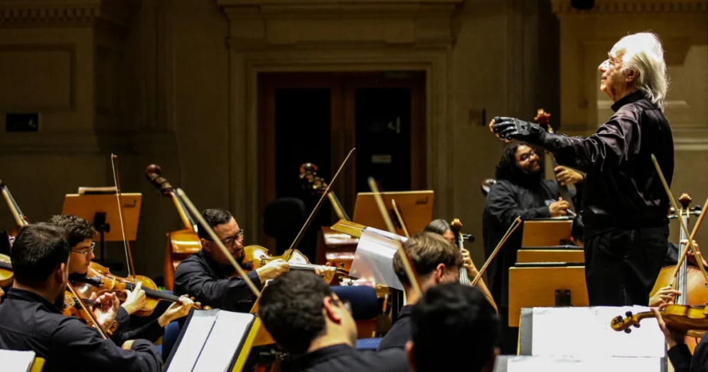 Foto do Maestro João Carlos Martins regendo uma orquestra