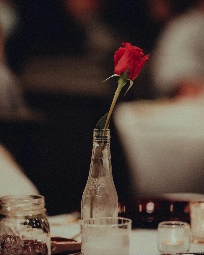 Uma flor dentro de uma garrafa vazia em uma mesa