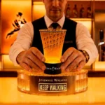 Imagem de um barmen segurando um copo da Johnnie Walker