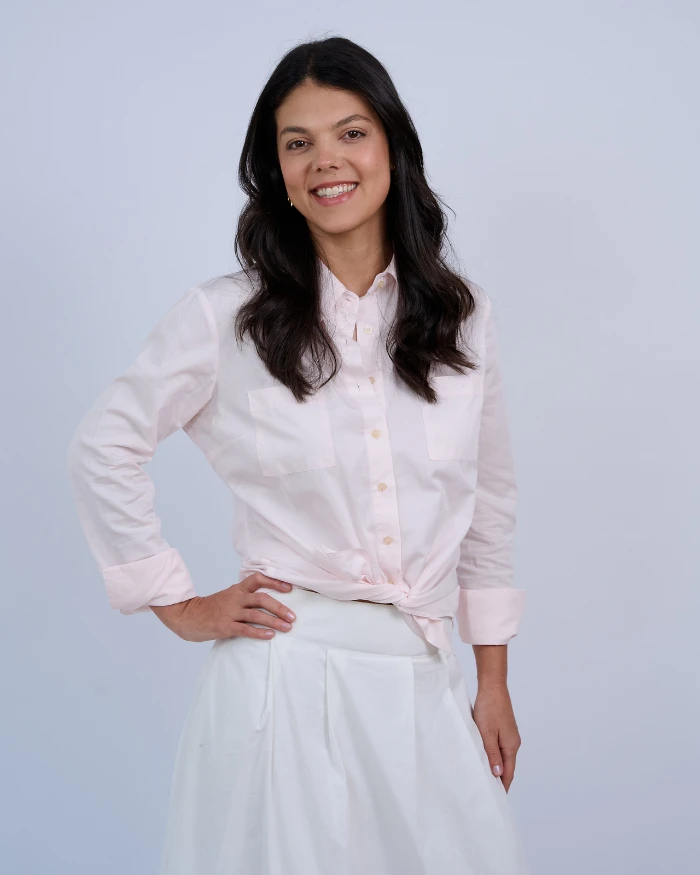 Foto de Eduarda Lopes, uma mulher branca, com cabelos pretos, camisa rosa claro e saia branca